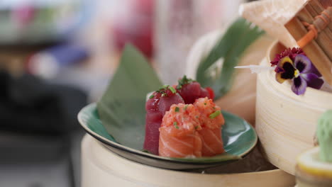 picking fresh tuna sushi roll in a plate using a pair of chopsticks - close up, slow motion