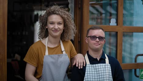 Portrait-of-cheerful-caucasian-waiters-when-one-with-down-syndrome.