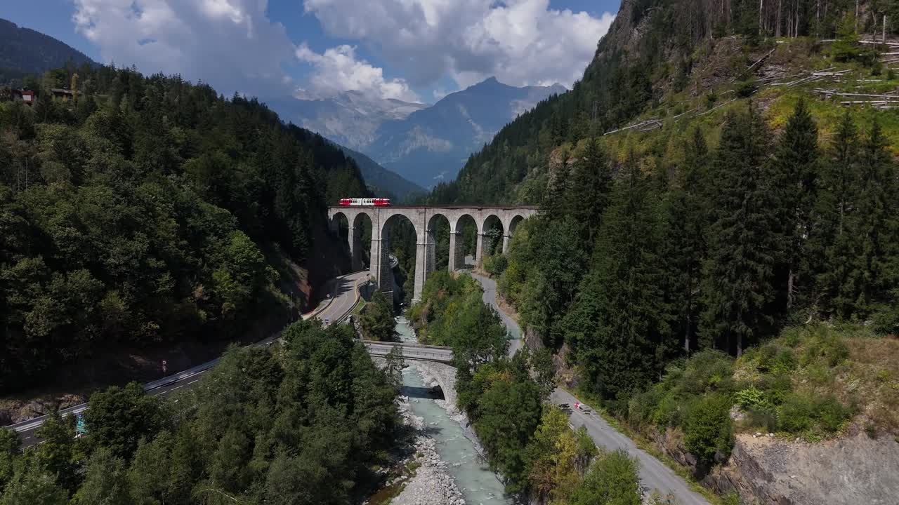 Drone voando para frente em direção a uma antiga ponte francesa nas montanhas com um trem passando em vídeos em 4K