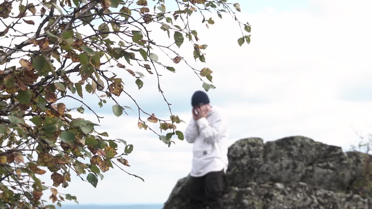 산 꼭대기 에 서 있는 사람, 전면 에 가을 잎자루