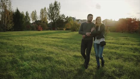 una pareja caminando en un parque al atardecer