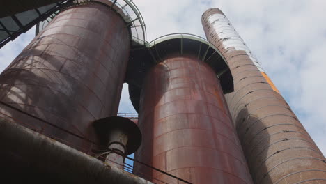 Low-angle-shot-of-World-Heritage-Site-with-old-chimney-stacks-of-Volklingen-ironworks-plant-in-Voelklingen,-Germany-on-a-sunny-day