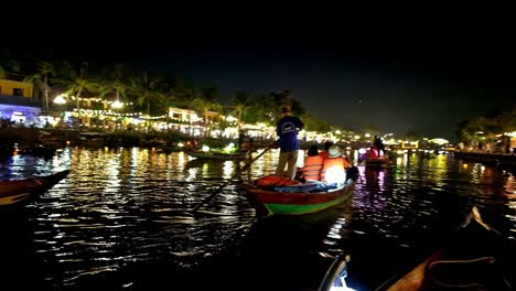 boatmen and boat ladies take tourists and visitors on an evening tour of thu bon river at a section of the old quarter in the city of hoi an, vietnam.