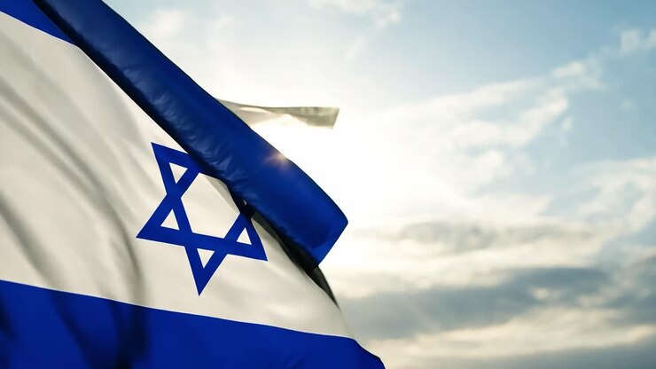Close-up of the Israeli flag waving in the wind against a blue sky