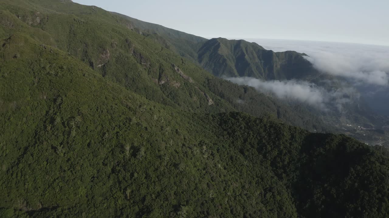 toma aérea sobre la isla de madeira con nubes bailando alrededor de la montaña y el valle en la distancia