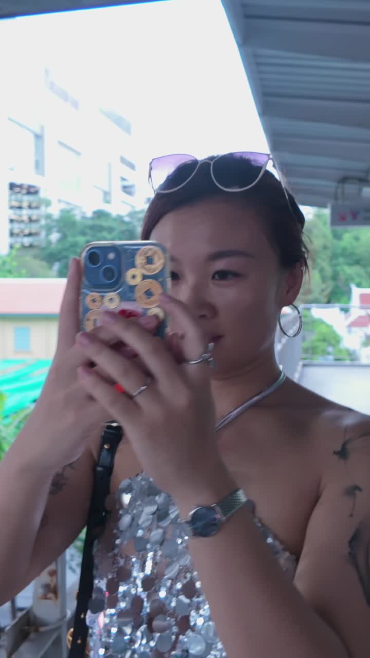 Woman with tattoos and jewelry taking photos