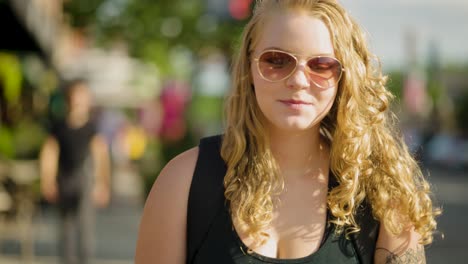 girl wearing sunglasses and long hair walks across crosswalk