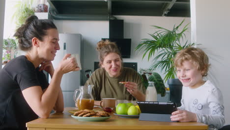 lgbtq family using digital tablet on breakfast