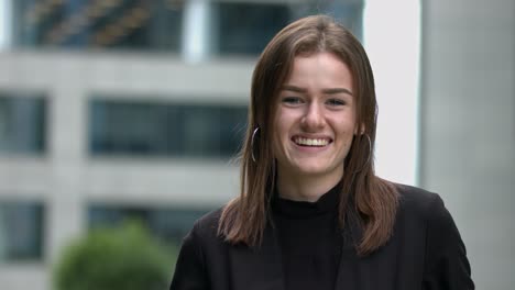 upper body portrait of pretty young woman standing and smiling, looking at camera