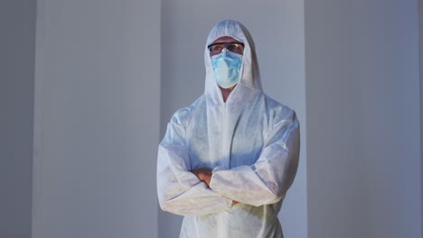 caucasian male medical worker wearing protective clothing with mask and safety glasses