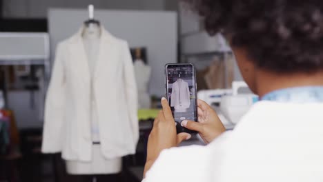 mujer de raza mixta tomando fotos en la oficina de moda