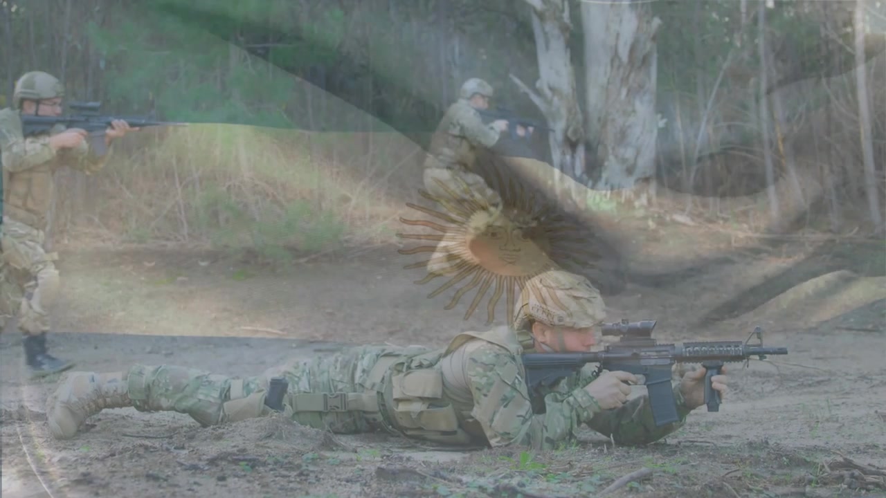 Ein Soldat scannt, ein anderer Soldat kommt an und zielt unter einem Flaggen-Overlay für militärisches Training.