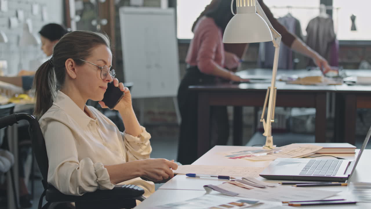 Optaget kvindelig modedesigner i telefonen