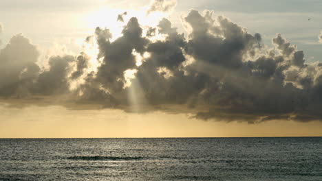 hermosa vista natural de los rayos de luz a través de las nubes en una puesta de sol en la playa de florida con vistas al horizonte y al mar