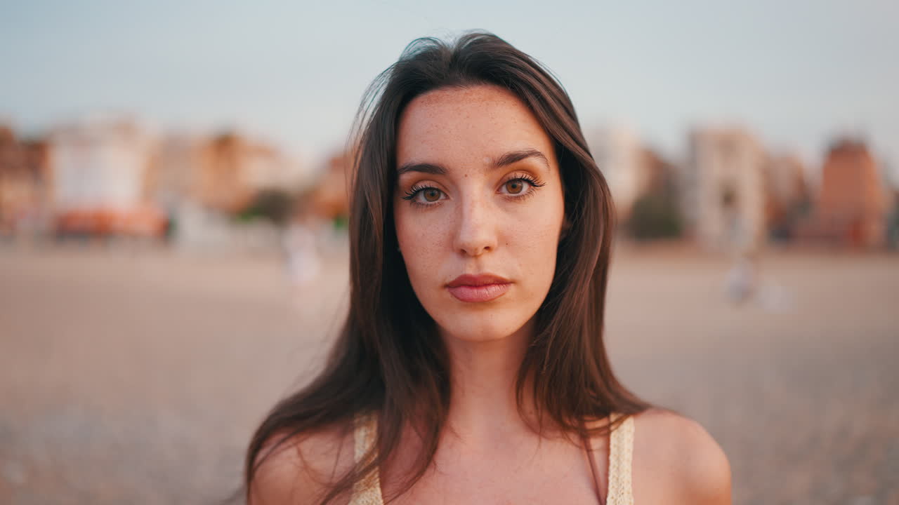 Ritratto di una donna bruna con lentiggini su una spiaggia