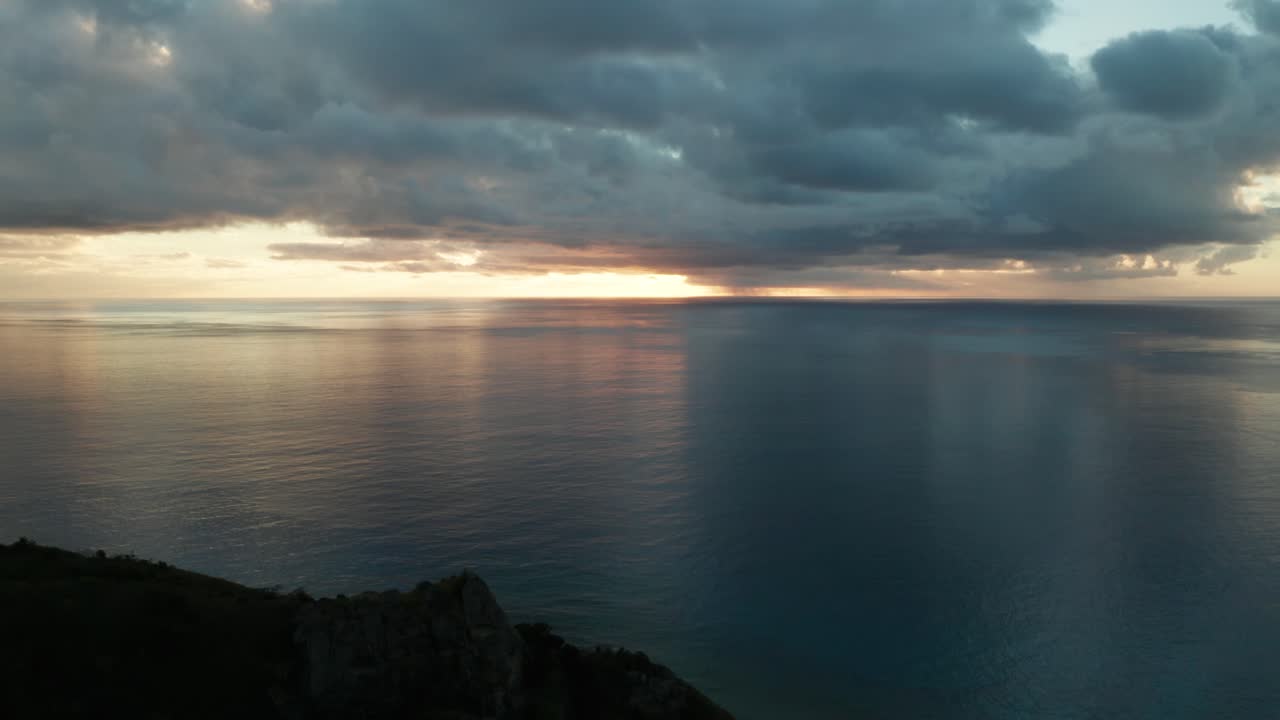 Flying through the rocky mountain island of Fiji with the bright sunset in the horizon
