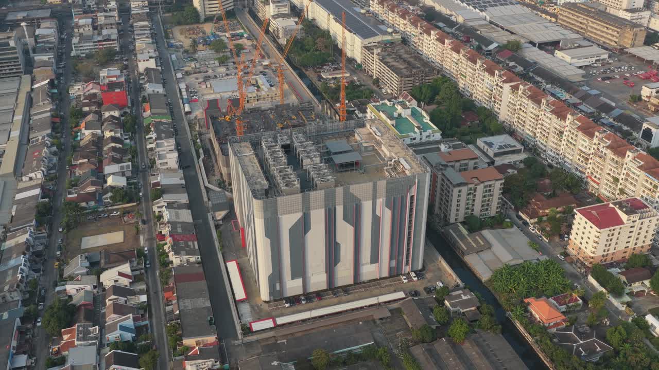 Vista aérea de gran angular de un gran y moderno edificio de centro de datos en construcción en el paisaje urbano de Bangkok, Tailandia, al atardecer.
