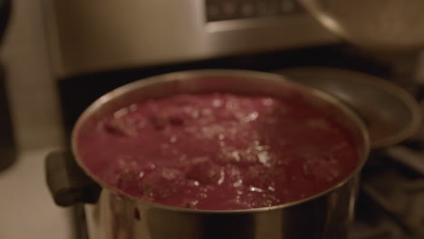 close up slow motion of a woman cooking meatballs in a pot