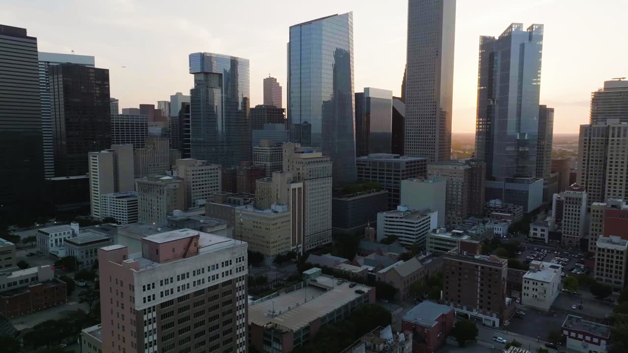 drone disparado volando hacia atrás desde el centro de houston, amanecer en texas, estados unidos