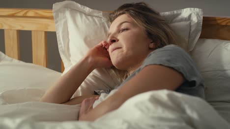 nervous caucasian woman lying in bed at morning.