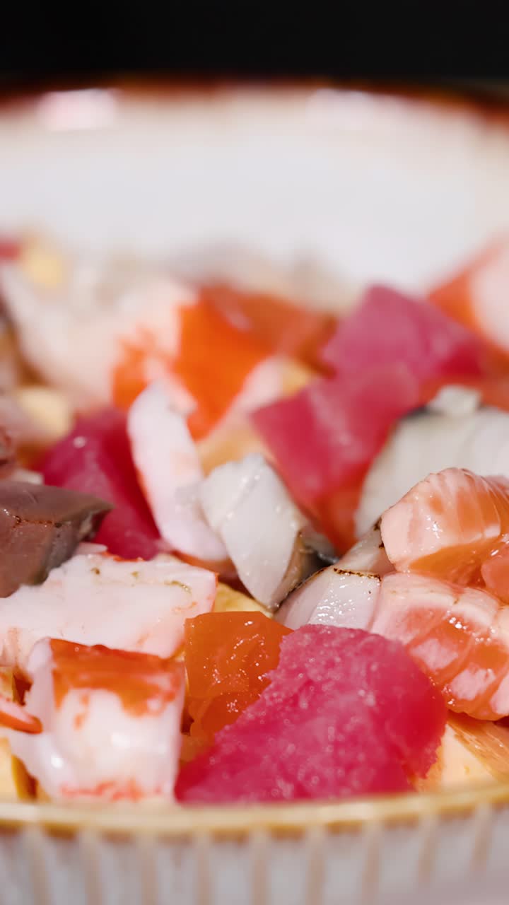 Gambar close-up tangan koki menggunakan pinset untuk menata mangkuk sushi chirashi hidangan laut gourmet
