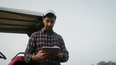 farmer using tablet near tractor