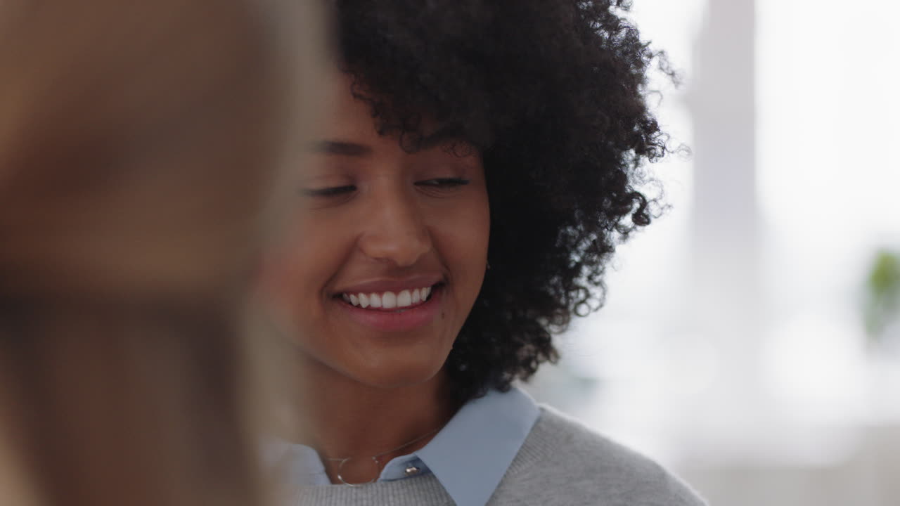 hermosa mujer de negocios de raza mixta con afro charlando con colegas compartiendo ideas disfrutando de la lluvia de ideas con el equipo en la oficina
