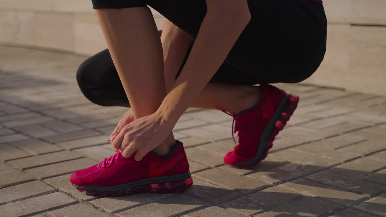 mujer atando sus zapatillas de correr al aire libre