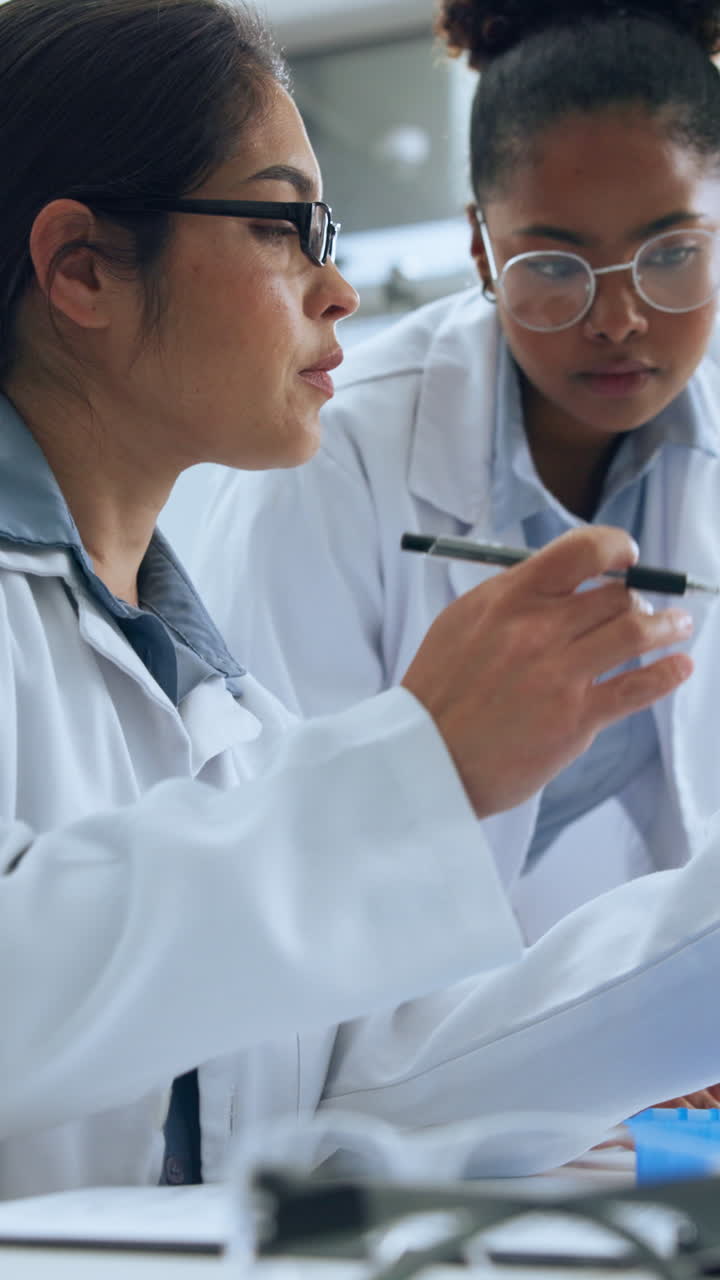 Due scienziate collaborano e discutono di ricerca in un laboratorio