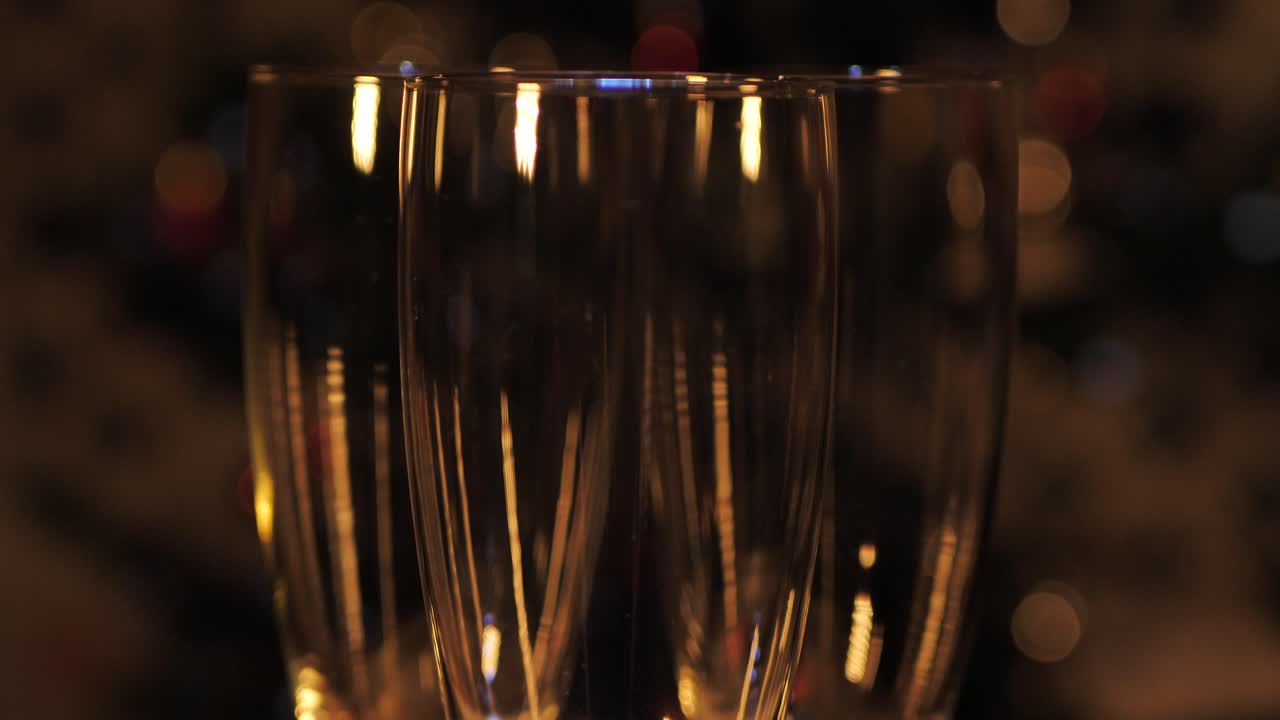 거품이 샴페인 잔에 반짝이며 천천히 회전합니다.