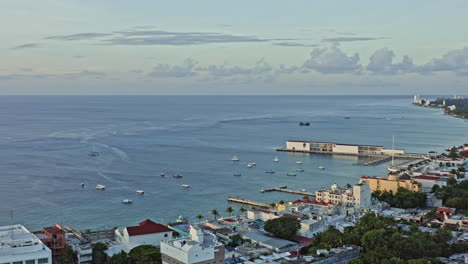 Toma-Panorámica-Aérea-V10-De-Cozumel-México-Que-Captura-La-Hermosa-Vista-Del-Atardecer-Del-Paisaje-Urbano-Del-Centro,-Las-Terminales-De-Cruceros-Y-El-Impresionante-Paisaje-Marino---Septiembre-De-2020