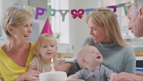 grandparents with mother and grandchildren celebrating with first birthday party at home