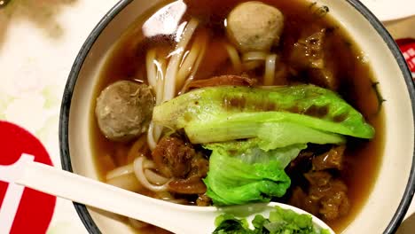 a bowl of beef noodle soup with vegetables