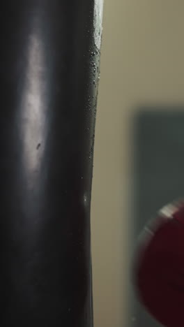 manos de hombre enérgico con experiencia en deportes golpeó saco de boxeo con fuerza con guantes de boxo en el gimnasio. practicando deportes profesionales en el sótano equipado
