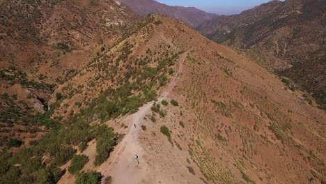 AERIAL---Downhill-bicycle-race-in-Farellones,-Chile,-wide-shot-forward