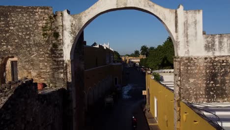 drone shot passing through a colonial arch in a town in mexico