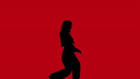 studio silhouette of woman dancing against red background