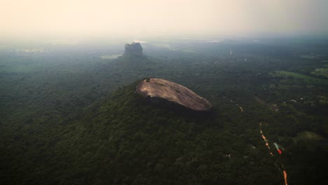 aerial view a jungle with fog and the beautiful pidurangala rock and lion tock at the background - sigiriya - sri lanka