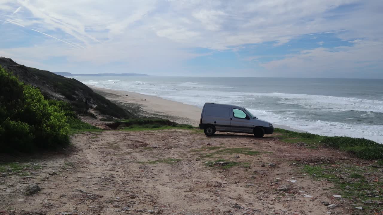 micro autocaravana estacionada junto a los acantilados sobre la playa de arena y el océano atlántico en portugal