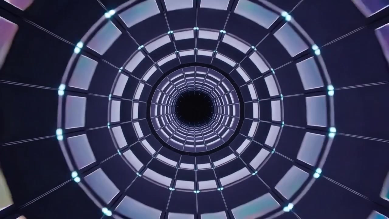 LED ciano pulsanti che avviano la rotazione, tunnel interno illuminato che ruota verso l'interno, enfatizzando la profondità.