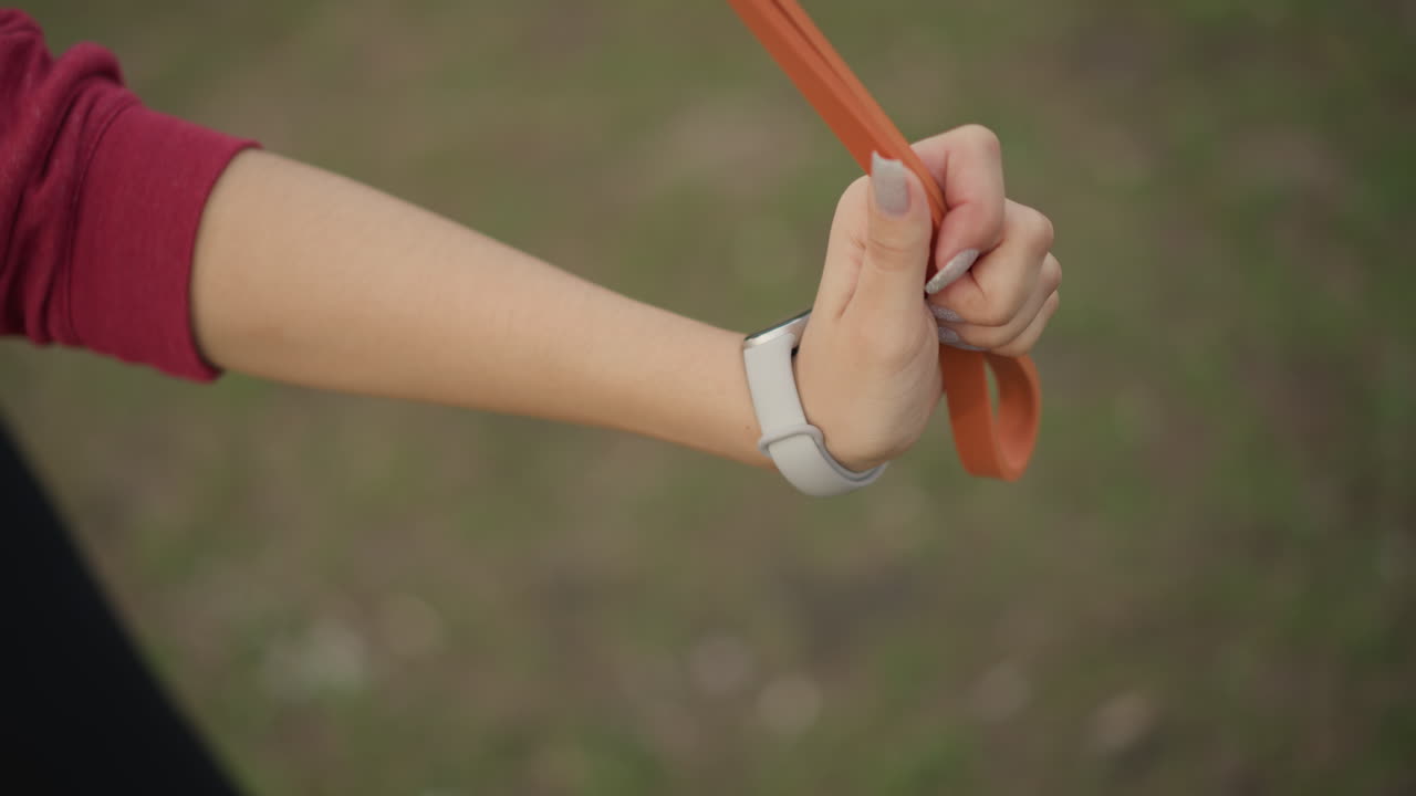 Holding Leash With Firm Control, Closeup Of Hand Gripping Leash For Dog Training Purpose, Focus On Hand Grasping Orange Leash Demonstrating Control During Outdoor Dog Training Activities