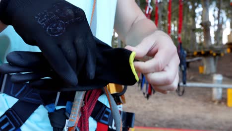 hombre poniendo guantes de mano mientras está de pie contra la tirolina 4k 4k