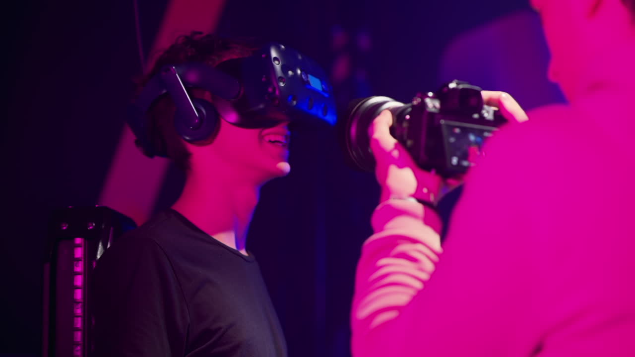 Operatore alla telecamera che riprende un ragazzo che gioca con un visore per la realtà virtuale in uno studio