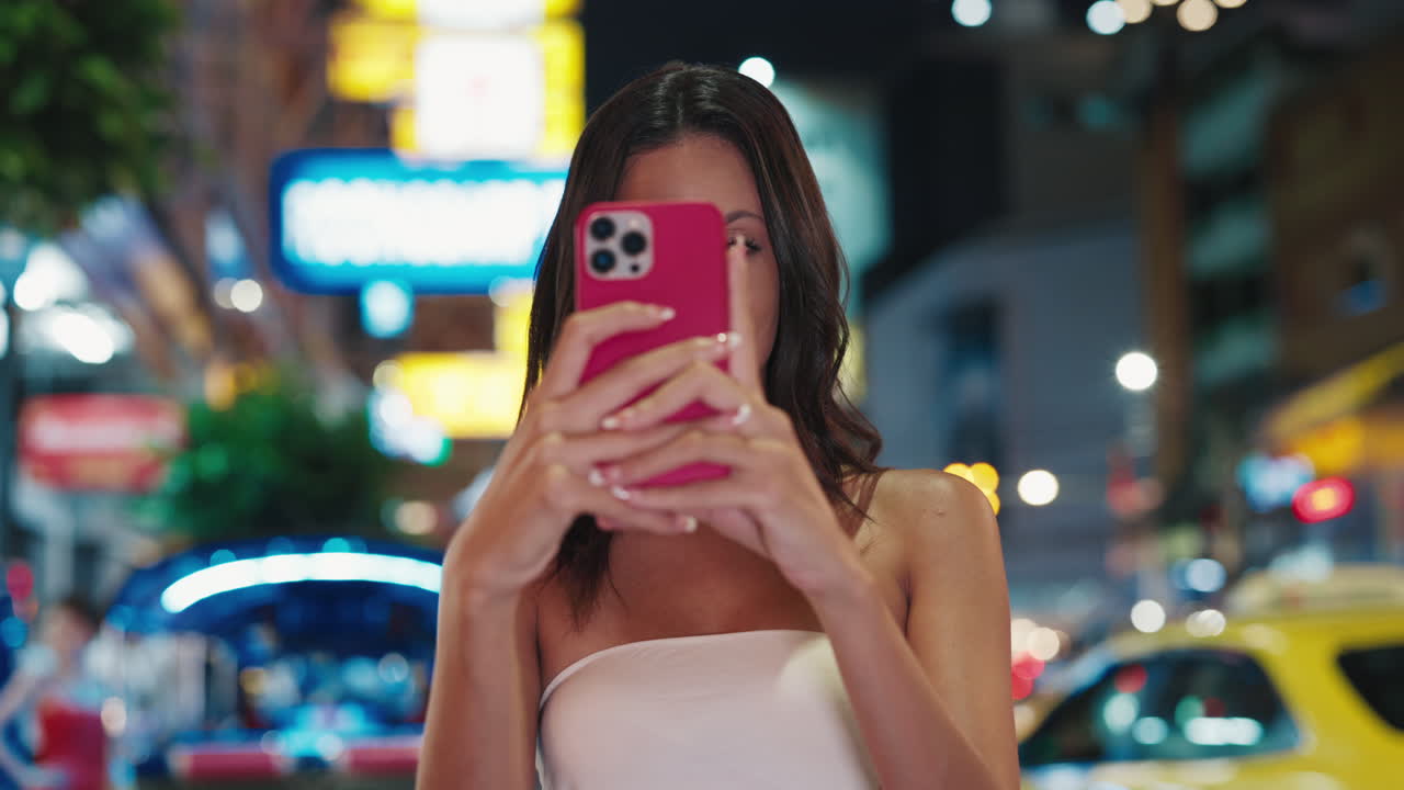 Woman taking a picture at night