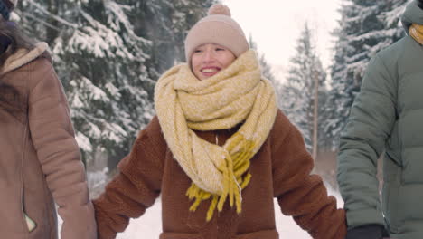 close up view of parents and daughter dressed in winter clothes walking in snowy forest 1