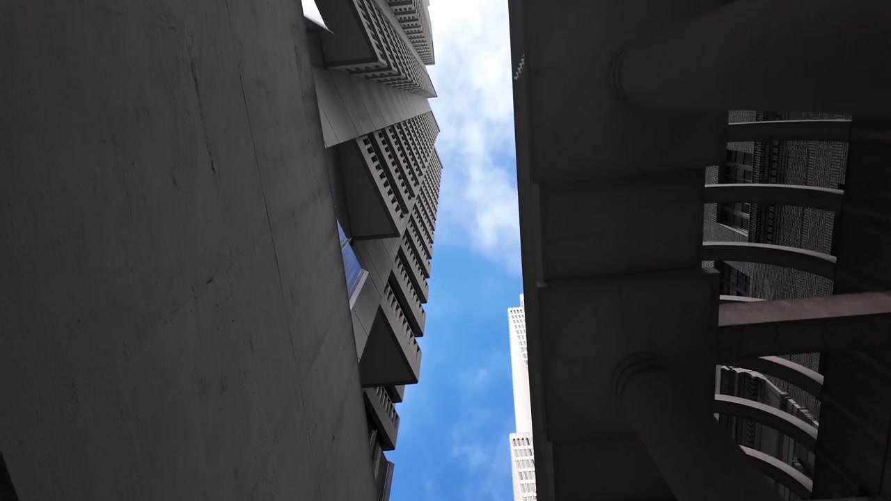 Cautivadora toma de ángulo bajo deslizándose entre los imponentes rascacielos del centro de San Francisco, dramática geometría de hormigón y cielo azul, ambiente urbano, luz diurna, enfoque arquitectónico.