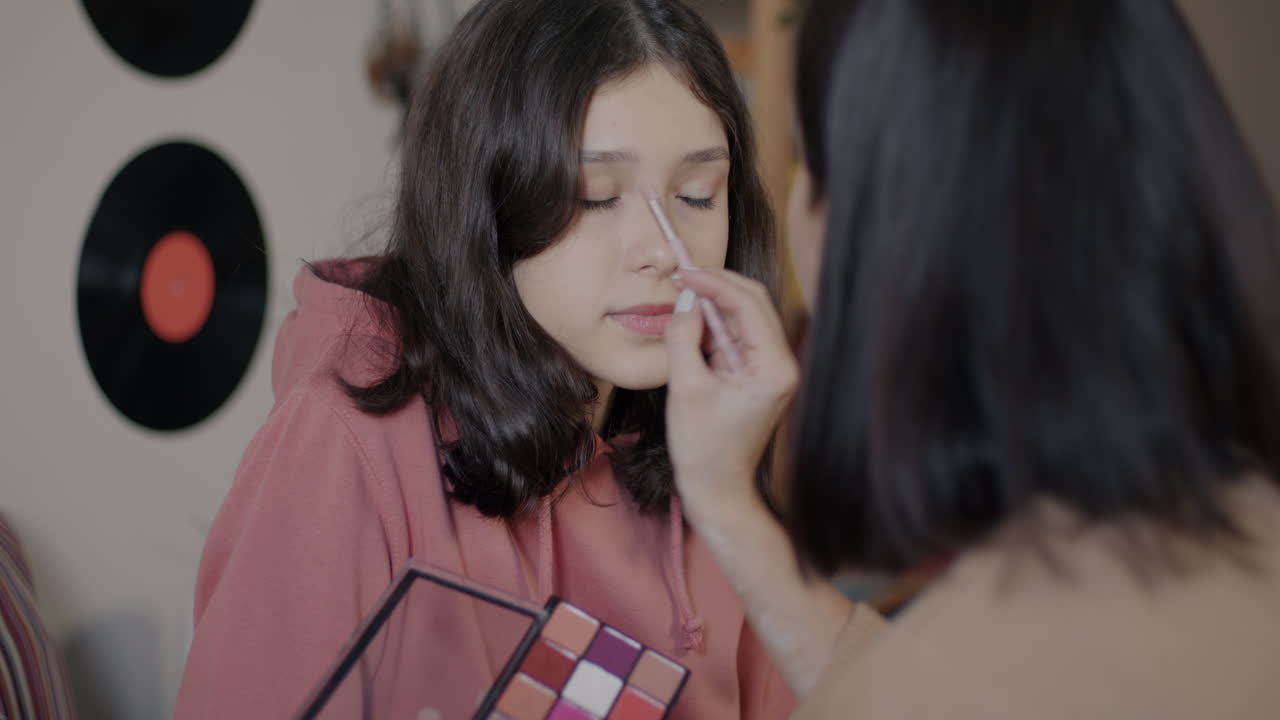 una adolescente haciendo su maquillaje