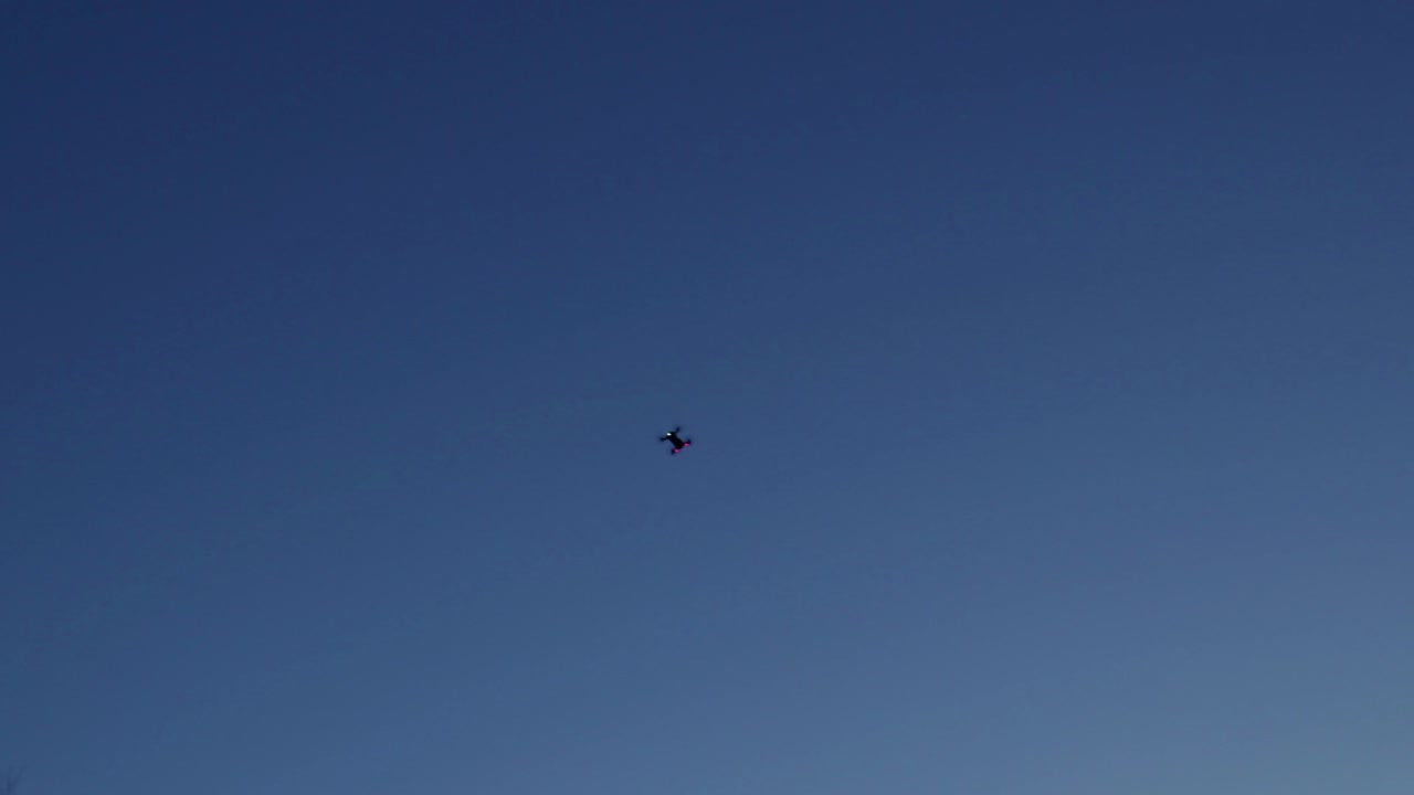 drone volando aislado como una silueta en un cielo azul