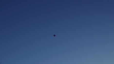 drone volando aislado como una silueta en un cielo azul