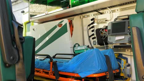 Emergency-medical-service-ambulance-vehicle-interior-with-modern-equipment,-bright-light,-nobody-inside,-paramedic-equipment,-handheld-panorama-shot-moving-left